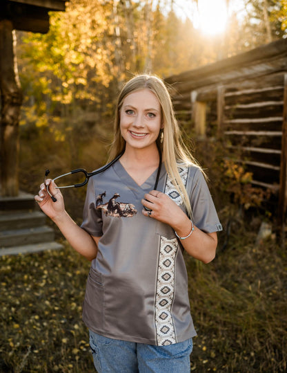 Woman holding a stethoscope in a scrub top with nature background