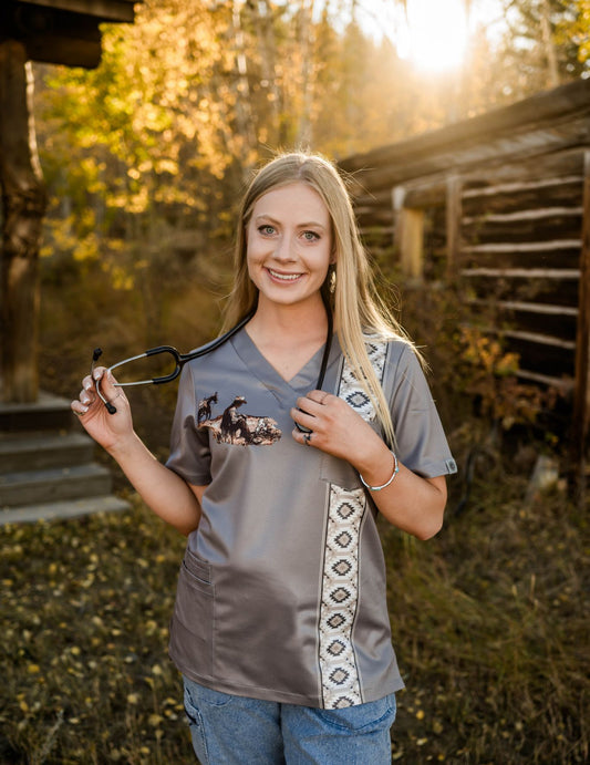 Woman holding a stethoscope in a scrub top with nature background